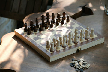 Folding wooden chess set on an outdoor table-