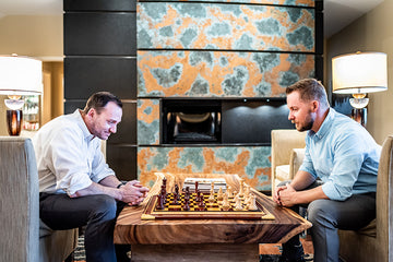 Two men playing chess at a coffee table